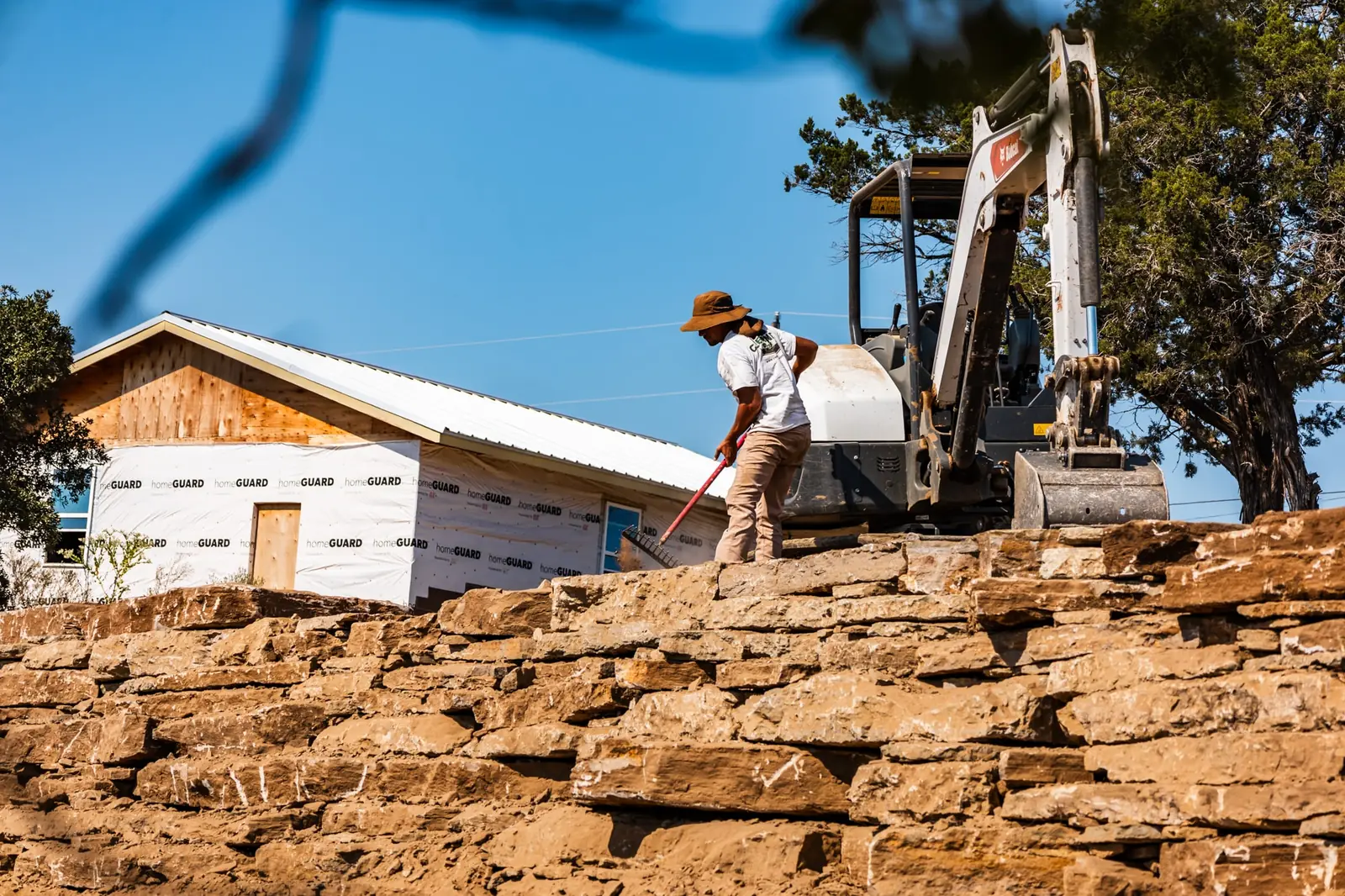 Crew setting native limestone on a stacked rock wall