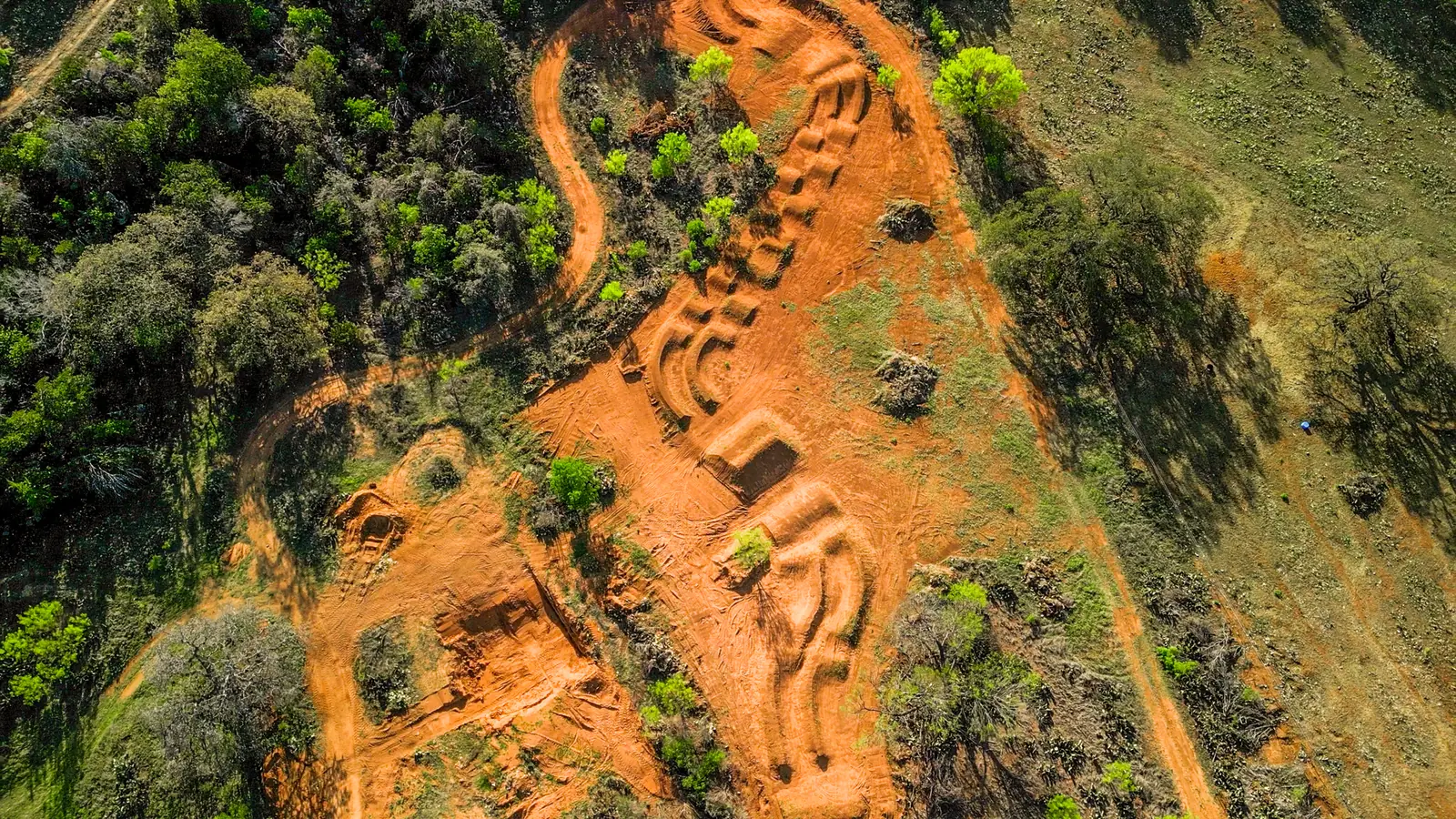 Aerial view of machine-built trails on a Hill Country hillside